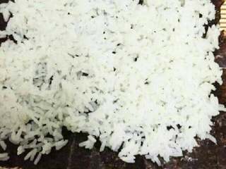 5、紫菜包饭,放上紫菜，把米饭放在紫菜上用饭勺压平，让米饭都黏在紫菜上。