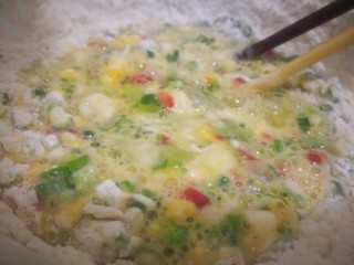 7、煎饼,倒入准备好的蔬菜粒，加入一碗水调成湖糊状，搅拌到没有面粉颗粒。