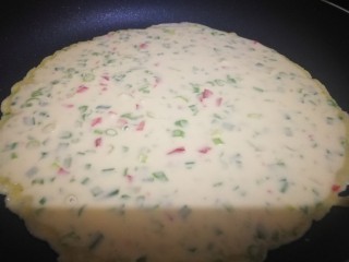 10、煎饼,根据锅的大小倒入适量面糊，左右晃动锅使得饼均匀分布。如图一定中小火慢慢煎