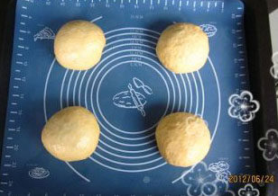 4、南瓜墨西哥红豆包,将松驰好的面团再次排气，压平，包上红豆馅，包好口，揉圆，整齐的摆放在烤盘上放