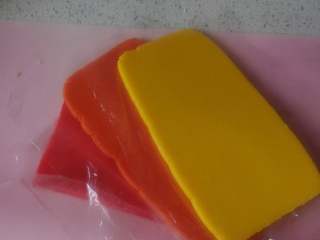 8、彩虹爱心饼干,算好尺寸，就可以准备擀面团啦~要擀到厚度均匀，有那种带刻度的擀面杖自然是最方便，如果没有，就找两本厚度差不多在5毫米的书，放在面团两侧，也是一样好用。把六种颜色分别擀成5毫米厚的片状。如果天气热，擀好就要放冰箱，避免面团变软影响了后面的造型。