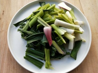 3、豉香腊肠炒蒜苗,蒜苗切去根须，洗净，切寸段。