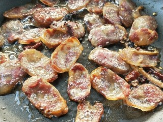 8、豉香腊肠炒蒜苗,煸至腊肠金黄色微微卷起。