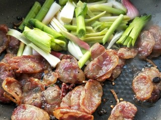 10、豉香腊肠炒蒜苗,放蒜苗的白色部分到油中。