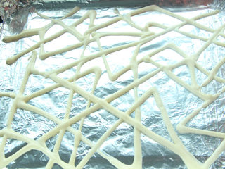 9、熔岩夹心蛋糕,取一小部分面糊装入裱花袋中,在铺有锡纸的烤盘上画出花纹。