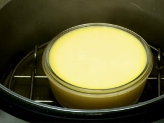 3、自製雞蛋豆腐,電鍋外鍋放入蒸架，加1杯水，按下開關蓋上鍋蓋，至蒸氣冒起、水開後，將作法2移入鍋中。