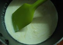 4、芒果布丁,隔水加热，放入糖和泡软的吉利丁片，至融化。