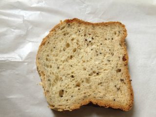 3、纸袋三明治,取两张油纸(一张也可以,两张更厚实些),将一片吐司放在中间;