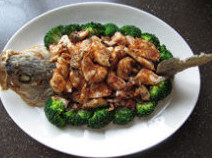 14、香辣鲈鱼,捞出沥油，盘中摆放鱼头、鱼尾、鱼肉和鱼骨，用熟西兰花围边