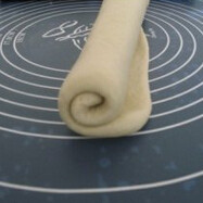 2、白巧克力面包干,将发酵好的面团排气滚圆,松弛15分钟,将面团擀成长方形并卷起