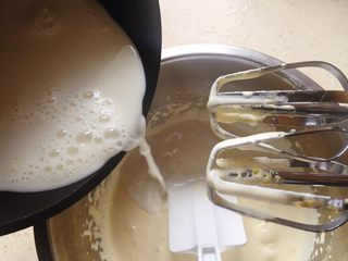 5、冰淇淋（无奶油版）,把刚才的牛奶慢慢倒一部分到蛋黄糊里面。搅拌均匀。