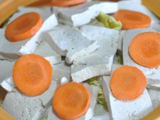 9、五花肉豆腐锅,放入切片的胡萝卜。