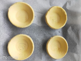 3、欧式风情下午茶|加了苹果的蛋挞,取一张和烤盘大小的油纸铺在烤盘上，把买回来的蛋挞皮一次铺在油纸上。