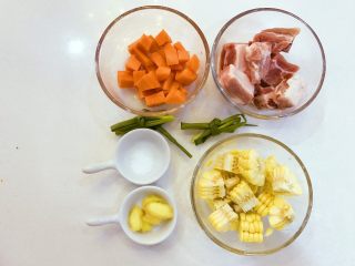1、宝宝辅食：胡萝卜玉米排骨汤-18M+,准备好所有食材，把排骨洗净，胡萝卜切小块，玉米也切小块，提前准备好一些姜片和葱，姜片尽量处理大点，葱打个结放入，炖完后可以取出来。