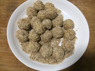 12、腰果开口笑,放入冷水中滚一圈取出,沾上芝麻搓紧。