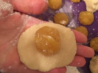 12、凤梨酥,凤梨皮平均分成15份，每份20克，取少量的面粉放在手心然后将面皮放在手心压扁，包上凤梨馅