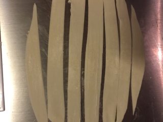 2、葱油面片,用刮板切成小条。