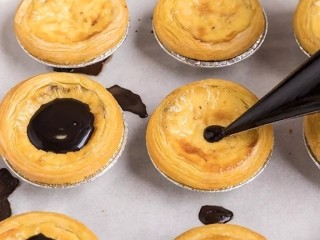 15、脏脏蛋挞,将巧克力酱均匀挤到烤好的蛋挞上