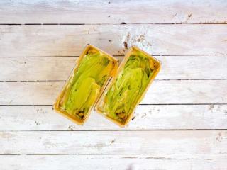 9、抹茶双色磅蛋糕,将抹茶面糊装入模具中，略微上下翻动，让其呈现出一个交错的图案，抹平