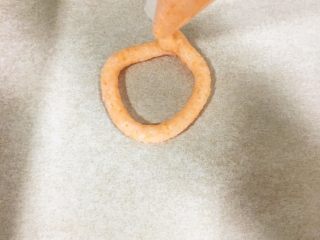 7、宝宝辅食9M➕：自制小零食----鲜虾圈,烤盘上铺一张烤纸，裱花袋剪个小口，裱花袋离烤纸有一定距离 边挤边转圈 这样出来的虾圈比较饱满