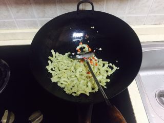 11、神下饭之酸苦瓜炒卤肥肠,倒入酸苦瓜翻炒，加盐，可以加一点生抽提味。