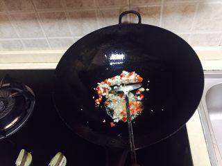 10、神下饭之酸苦瓜炒卤肥肠,再加少许油加热，倒入小米椒碎和蒜末炒香。