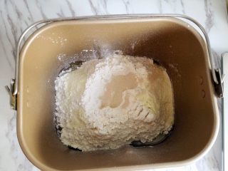 1、香葱火腿包,面包机揉面，将面包食材部分按照先液体再粉末的顺序投入面包机里，揉面至扩展阶段，