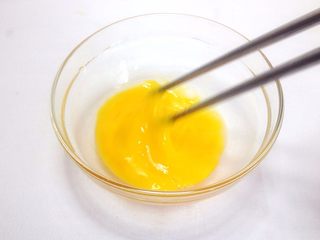 1、奶香小米布丁,鸡蛋磕入碗里，搅打均匀；