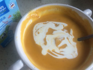 4、奶油南瓜羹,南瓜泥倒到碗里，加入牛奶，用勺子搅拌均匀，再加入淡奶油拌匀