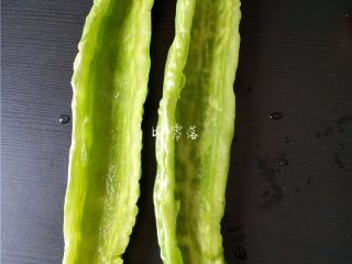 2、苦瓜蛋脯,苦瓜对半剖开，用勺子挖掉苦瓜籽，苦瓜瓤；苦瓜里的白色的物质一定要挖干净，否则会发苦；