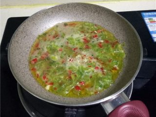 11、苦瓜蛋脯,倒入苦瓜蛋液，借助铲子将食材铺均匀；