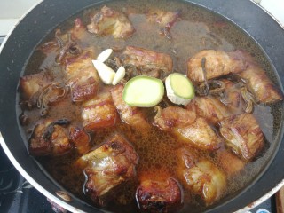 15、#那一抹家乡味#妈妈菜干豆角烧肉,一碗热水，水刚刚没过肉就可以了，加入生姜和蒜瓣。