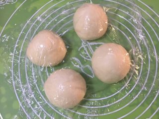 12、红豆心形面包,面团先分成二个剂子，一个剂子放冰箱冷藏，另一个剂子分成四份，盖上保鲜膜静置20分钟。