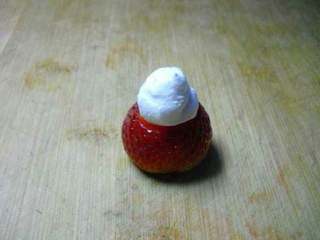 4、草莓雪人,把奶油放上去。