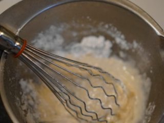 2、芒果烫面蛋糕卷,牛奶和植物油用小火煮到65度左右关火,搅拌均匀后筛入低粉,搅拌至无干粉