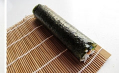 8、紫菜包饭,卷好后，压着竹帘再用力压一下，定形。