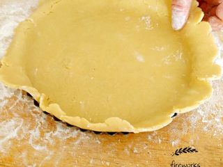 11、圣诞苹果派-超级酥皮,12. 大块面团从冰箱取出后擀面杖铺开,铺在圆形派盘底部。用叉子在面皮表面刺出小孔后备用。