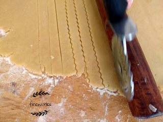 13、圣诞苹果派-超级酥皮,13. 取出另外面团，用面锤做成一个薄厚均匀的大面片，用刀具划成粗细均匀的长条状.（注意可以用擀面杖比在面皮上。）