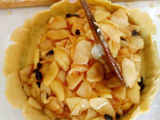 14、圣诞苹果派-超级酥皮,14.把凉凉的苹果内馅倒入面底中，要铺的厚度均匀。