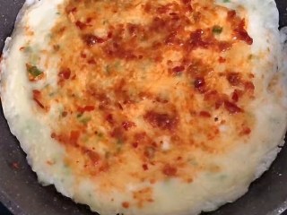 11、#懒人料理#黄金鸡蛋饼,翻面后，抹些蒜蓉辣酱。