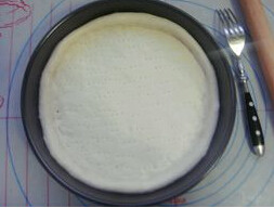 3、简易腊肠披萨 ,将发好的面团取出，排气，擀成略大于披萨盘的圆片，盘内涂油，摆入饼皮