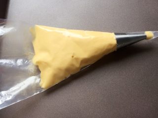 11、百变鸡蛋+蛋黄溶豆,将拌好的蛋黄糊,装入裱花袋中。