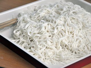 6、龙须凉面,在面条里加入香油，用筷子将面条抖开抖散，细面条这一步要动作轻，避免扯断，如果不喜欢吃细面，可选择粗一号的面条，这样更劲道。