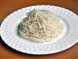 11、龙须凉面,将凉面、豆芽放在盘里。