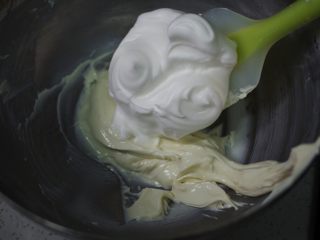 6、只用蛋清的美味烘焙 | 酸奶溶豆,挖取三分之一蛋白霜，到酸奶糊中，拌匀。速度要快，简单拌三五次就可以了。