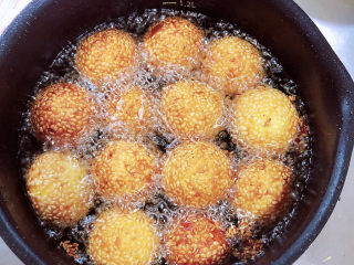 14、南瓜芝麻球,逐一放入南瓜球，南瓜球加热后慢慢漂起，炸至焦黄即可捞出控油。