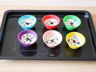 11、蔓越莓米糕,倒入硅胶模具中，表面撒适量熟黑芝麻，中间放上一颗蔓越莓干；