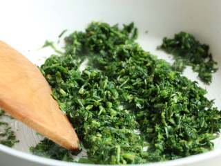 7、荠菜春笋炒年糕,锅中加入油，七八成热时倒入荠菜末，中大火翻炒20秒。