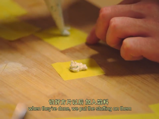 9、那不勒斯松枝饺子,馅料装入袋子，接着剪开一个口子，馅料加到面皮上，折成三角形，将两头连到一起