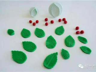 5、可爱到不忍下口的冰雪奇缘3D蛋糕|翻糖蛋糕教学,利用叶子模具印出绿色翻糖叶子,用红色翻糖搓出数颗小果实